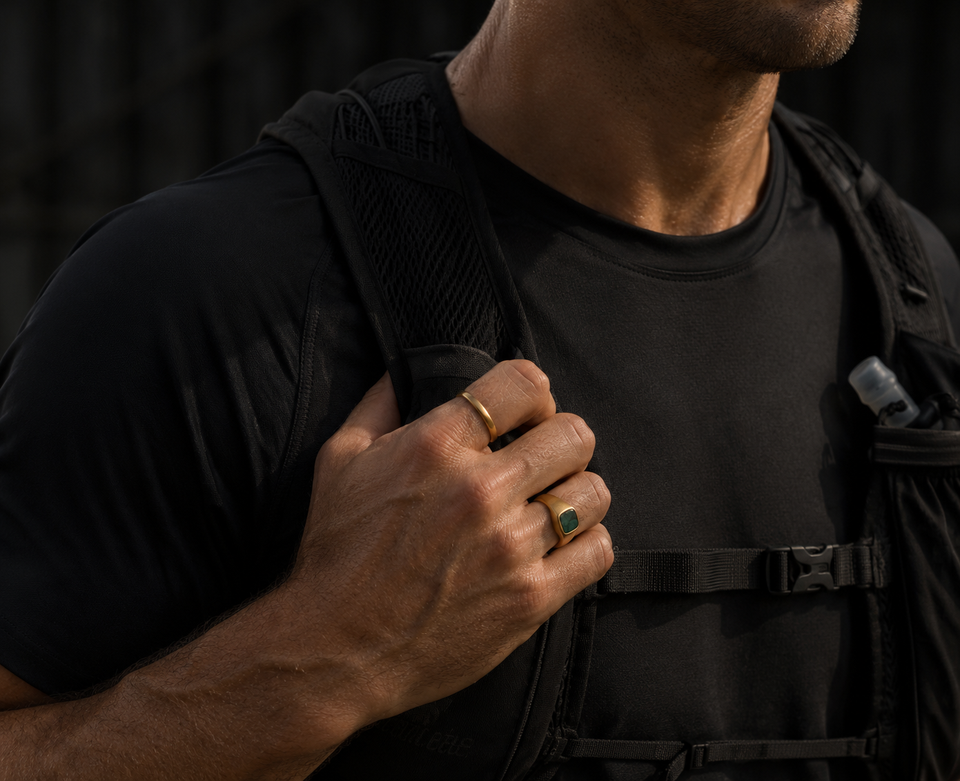 Person wearing a black backpack with a dark background